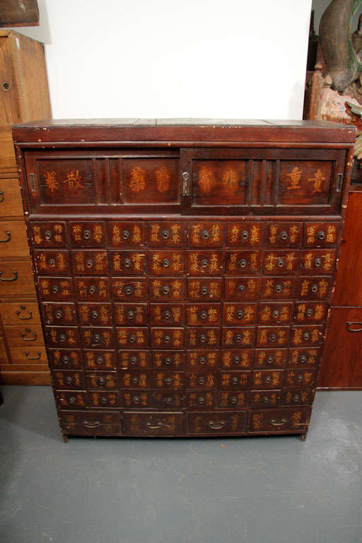 Antique homeopathic apothecary (medicine) chest with compartmentalized drawers and panels.
